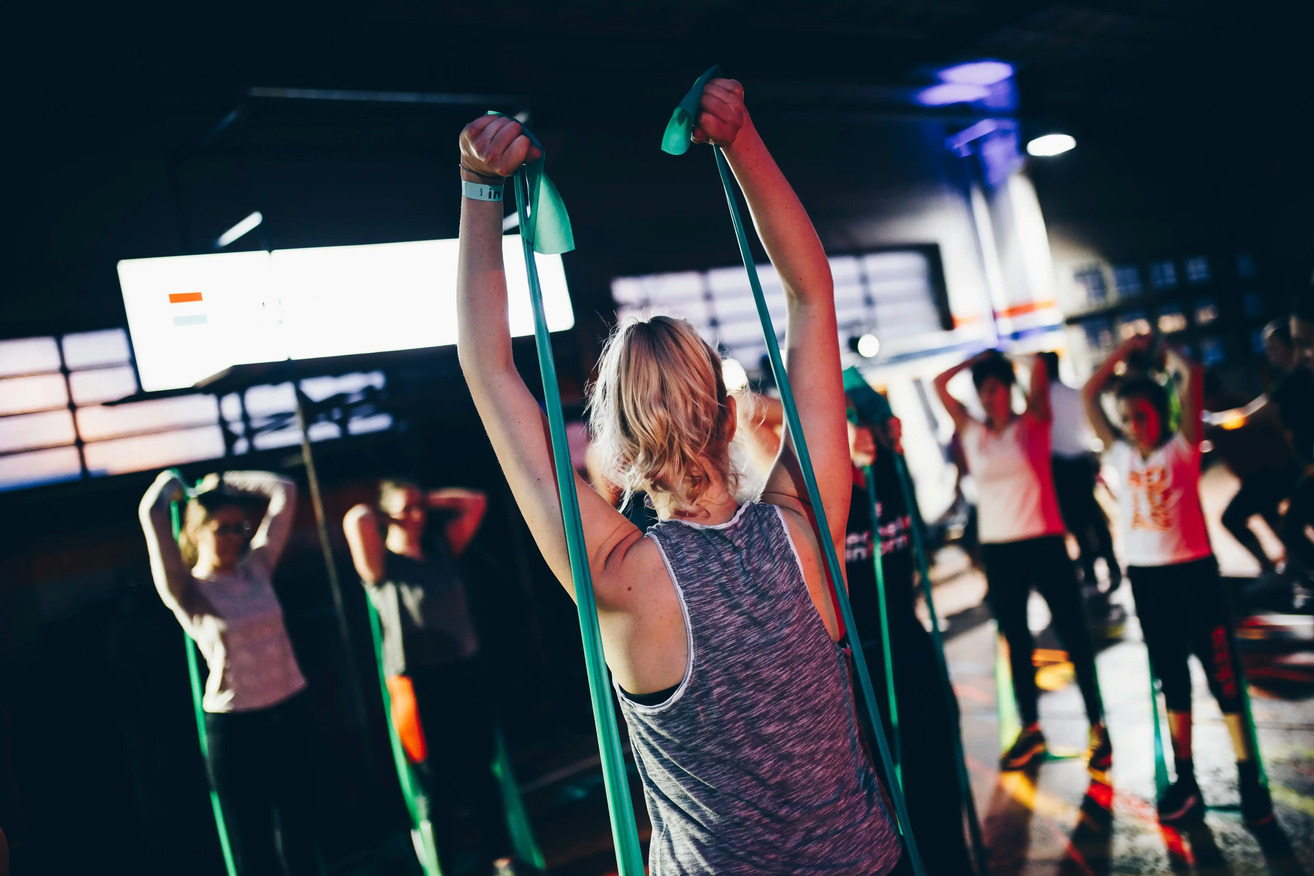 Kvinna som strecthar med gummiband. Bodyflight är en av många godkända friskvårdsaktiviteter.