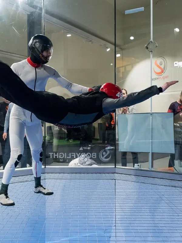 Person i röd hjälm som flyger i vindtunneln.